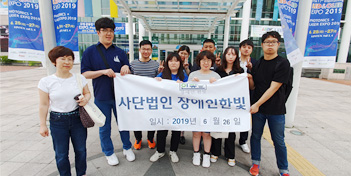 박람회장에서 단체로 현수막을 들고 있는 모습